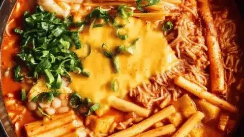 Delicious Budae Jjigae, a traditional Korean Army Stew, served in a cozy setting.