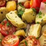 Fresh Tuscan Artichoke Tomato Salad garnished with herbs and olive oil