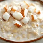 Delicious Coconut Cream Pie Overnight Oats topped with coconut flakes and fruits.