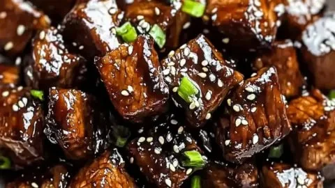 Deliciously prepared Asian steak bites garnished with herbs and spices.