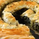 Savory flaky Spanakopita spiral, a delicious Greek snack on a plate