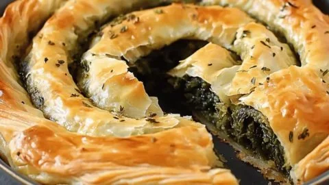 Savory flaky Spanakopita spiral, a delicious Greek snack on a plate
